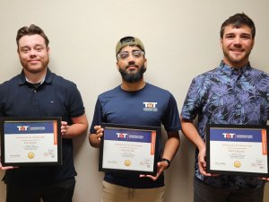 three T&T Construction interns posing with completion plaques