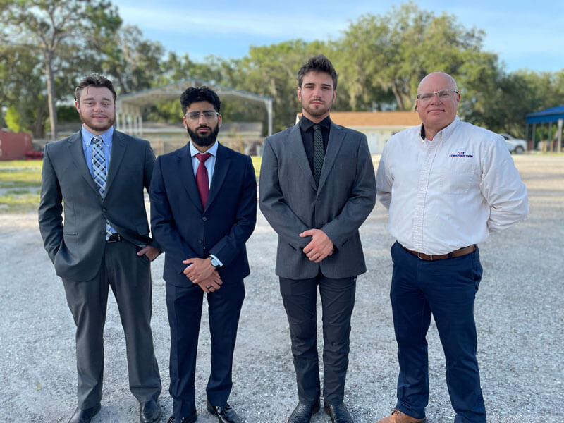three T&T Construction intern program members standing in field